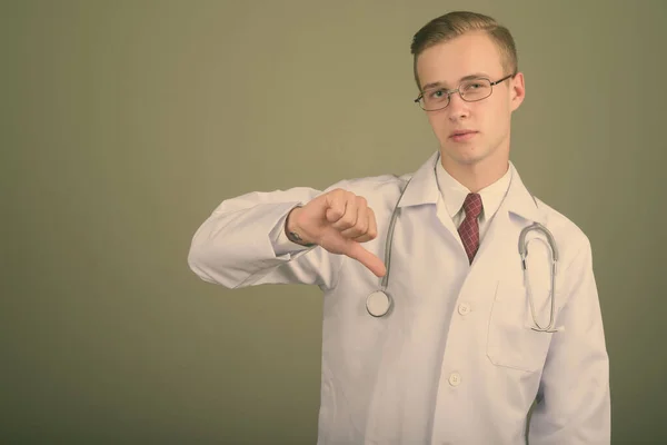 Joven hombre guapo médico contra el fondo de color —  Fotos de Stock