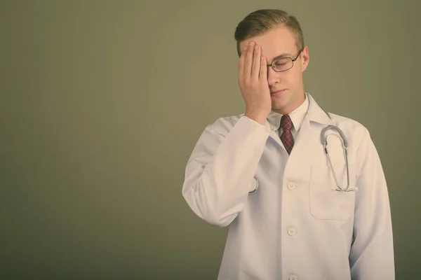 Ung stilig man läkare mot färgad bakgrund — Stockfoto