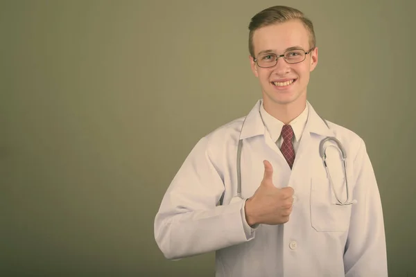 Jonge knappe man arts tegen gekleurde achtergrond — Stockfoto