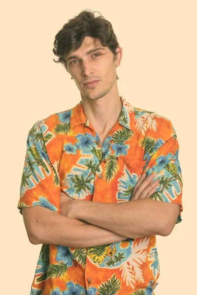 Studio shot of young handsome man with arms crossed — Stock Photo, Image