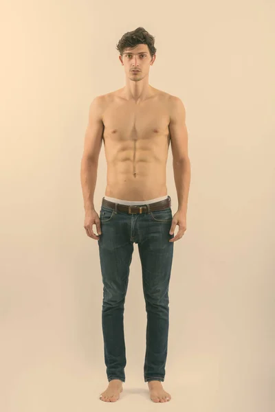 Full body shot of young handsome man standing shirtless — Stock Photo, Image