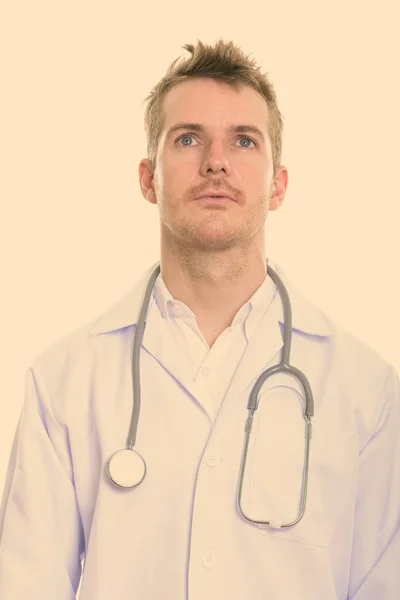Портрет красивого мужчины-врача с светлыми волосами, думающего: — стоковое фото