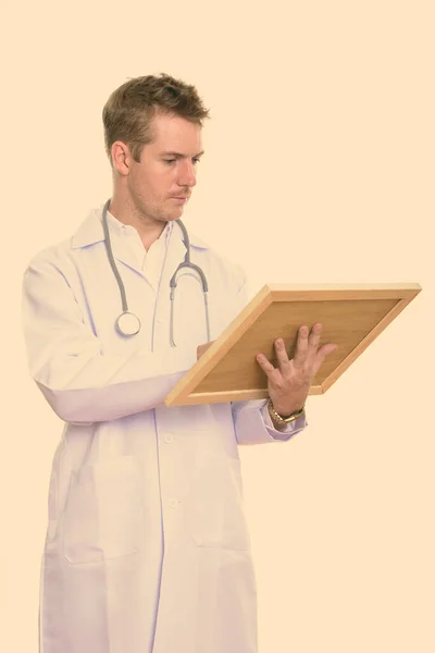 Estudio plano de hombre médico leyendo en tablero de madera — Foto de Stock