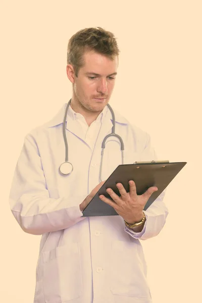 Studioaufnahme eines Arztes beim Lesen auf Klemmbrett — Stockfoto