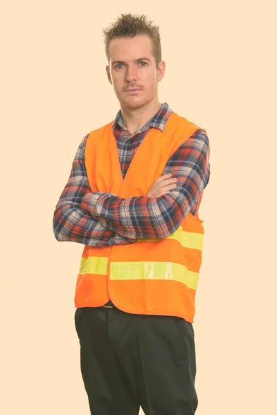 Studio shot of man construction worker standing with arms crossed — Stock Photo, Image