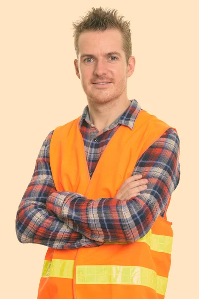 Estúdio tiro de homem feliz trabalhador da construção sorrindo com os braços cruzados — Fotografia de Stock