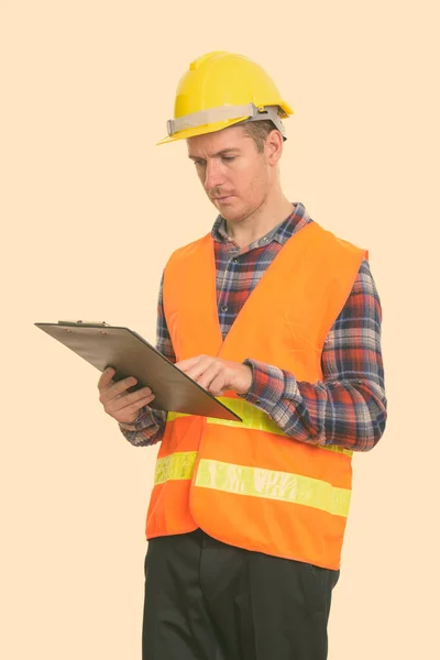 Estudio plano de hombre trabajador de la construcción leyendo en portapapeles —  Fotos de Stock