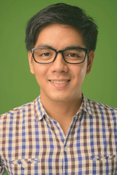 Joven hombre filipino guapo sobre fondo verde — Foto de Stock