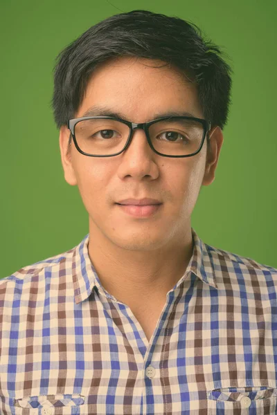 Joven hombre filipino guapo sobre fondo verde —  Fotos de Stock