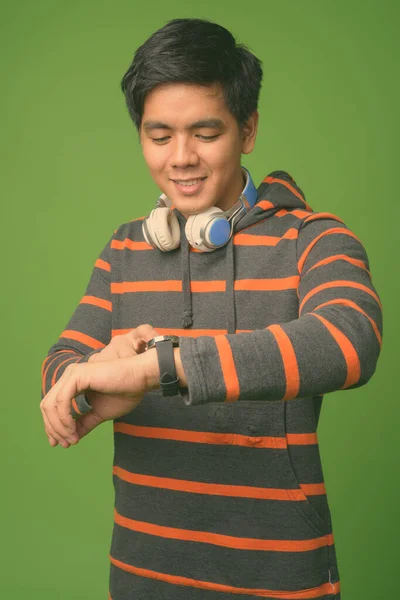 Młody przystojny Filipino człowiek na zielonym tle — Zdjęcie stockowe