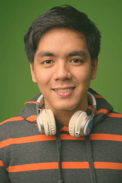 Молодий вродливий філіппінець проти зеленого фону. — стокове фото