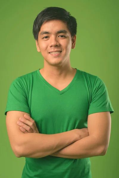 Jovem filipino bonito contra fundo verde — Fotografia de Stock