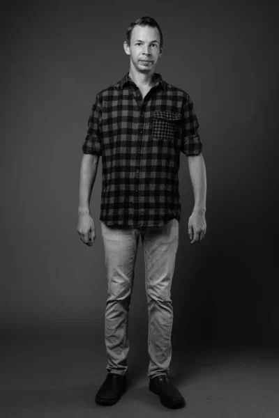 Studio shot of hipster man against gray background — Stock Photo, Image