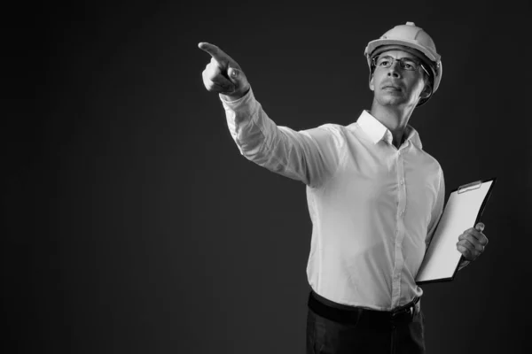 Porträtt av affärsman bär hatt mot grå bakgrund — Stockfoto