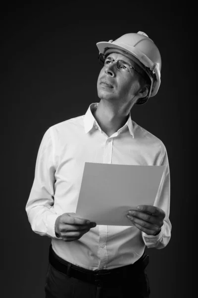 Porträtt av affärsman bär hatt mot grå bakgrund — Stockfoto