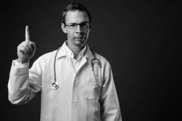 Студійний знімок лікаря чоловіка на сірому фоні — стокове фото