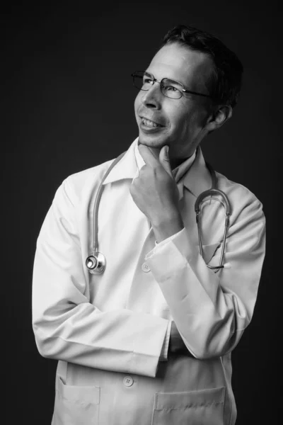 Студійний знімок лікаря чоловіка на сірому фоні — стокове фото