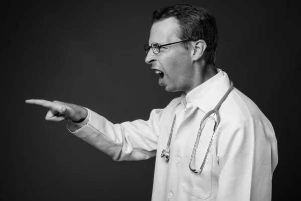 Estúdio tiro de homem médico contra fundo cinza — Fotografia de Stock