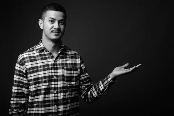 Joven multi étnico asiático hombre contra gris fondo — Foto de Stock