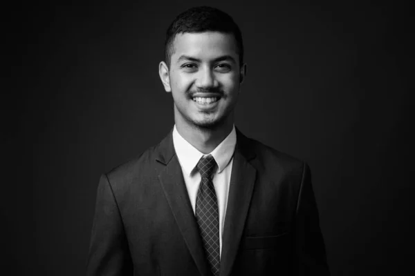 Joven multi étnico asiático hombre de negocios en traje contra fondo gris —  Fotos de Stock