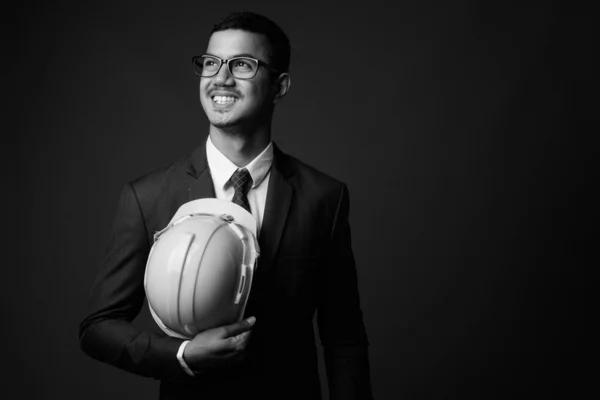 Joven multi étnico asiático hombre de negocios en traje contra fondo gris — Foto de Stock