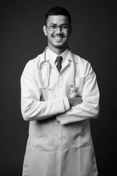 Молодой многонациональный врач-азиат на сером фоне — стоковое фото