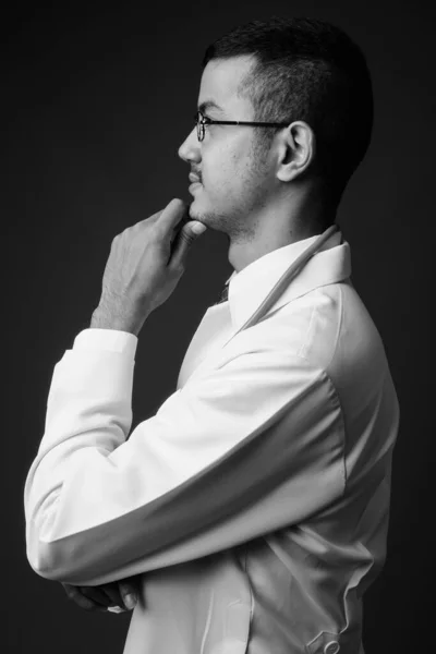 Junger multiethnischer asiatischer Arzt mit grauem Hintergrund — Stockfoto