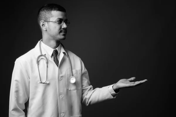 Young multi ethnic Asian man doctor against gray background — Stock Photo, Image