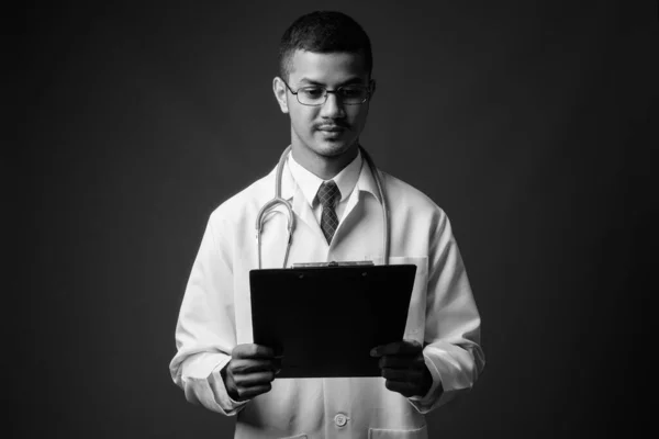 Junger multiethnischer asiatischer Arzt mit grauem Hintergrund — Stockfoto