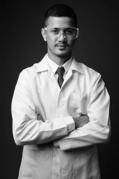 若い多民族アジア人男性医師に対する灰色の背景 — ストック写真