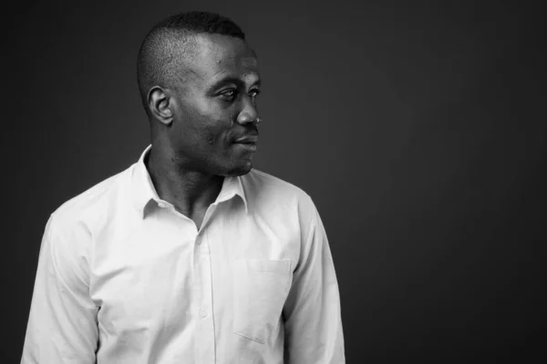 Studio shot of young African businessman against gray background — Stock Photo, Image