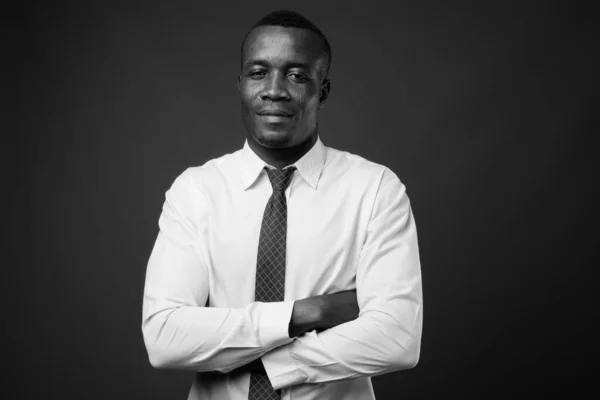 Studio shot of young African businessman against gray background — Stock Photo, Image