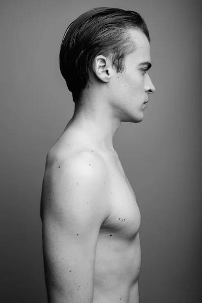 Νεαρός όμορφος άντρας χωρίς μπλούζα σε γκρι φόντο — Φωτογραφία Αρχείου