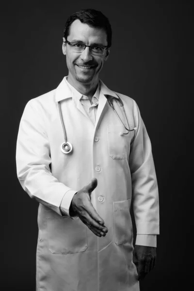 Retrato de homem bonito médico contra fundo cinza — Fotografia de Stock