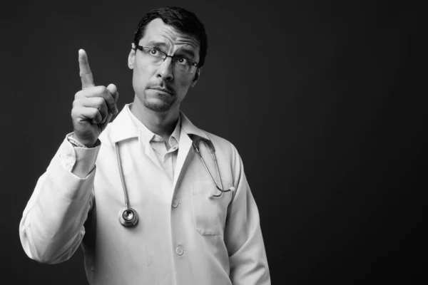 회색빛 배경 과는 대조적으로 잘생긴 의사의 모습 — 스톡 사진