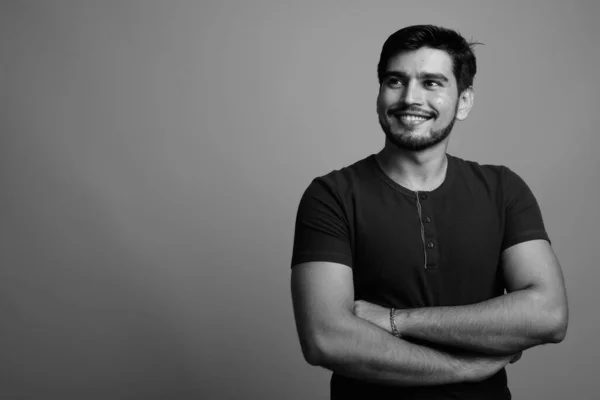 Joven guapo barbudo persa hombre sobre fondo gris — Foto de Stock