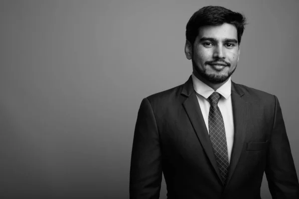 Mladý pohledný vousatý perský podnikatel proti šedému pozadí — Stock fotografie