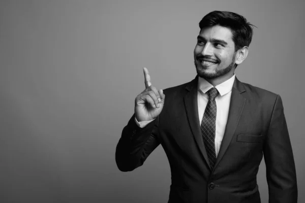 Giovane bell'uomo d'affari persiano barbuto contro sfondo grigio — Foto Stock