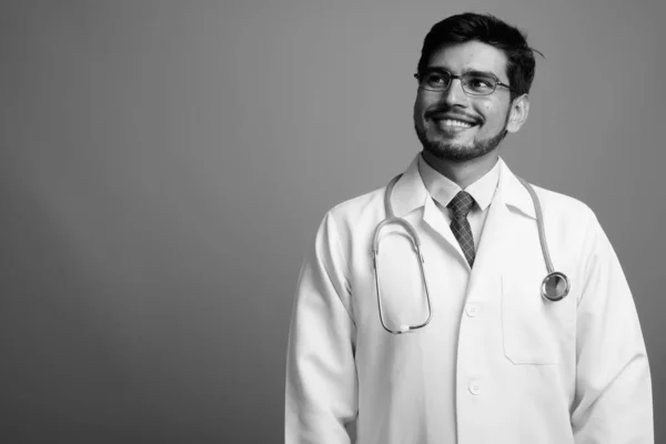 Jovem bonito barbudo persa homem médico contra fundo cinza — Fotografia de Stock