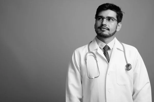 수염 이난젊고 잘생긴 페르시아 사람, 회색 배경에 반대하는 의사 — 스톡 사진
