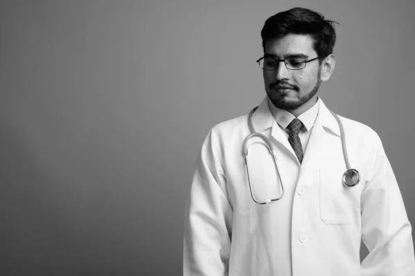 수염 이난젊고 잘생긴 페르시아 사람, 회색 배경에 반대하는 의사 — 스톡 사진