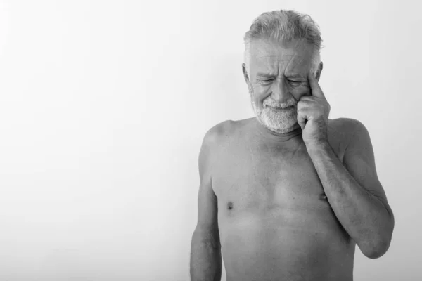 Studio záběr pohledný starší vousatý muž myšlení při pohledu stres bez košile na bílém pozadí — Stock fotografie