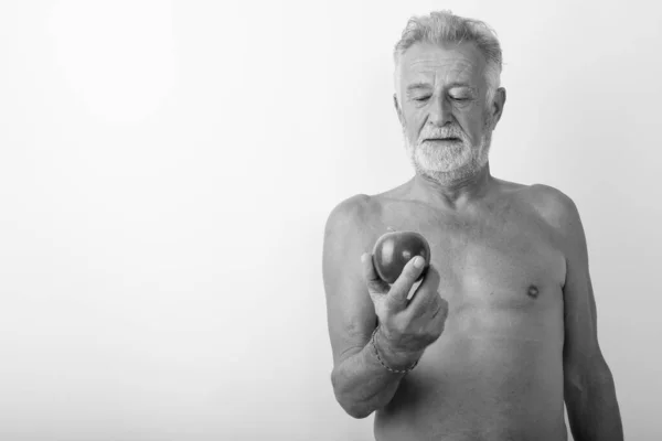 Studio colpo di bello anziano barbuto uomo guardando mela a torso nudo su sfondo bianco — Foto Stock