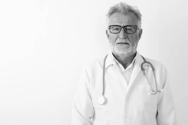 Studio colpo di bello anziano barbuto uomo medico indossare occhiali contro sfondo bianco — Foto Stock