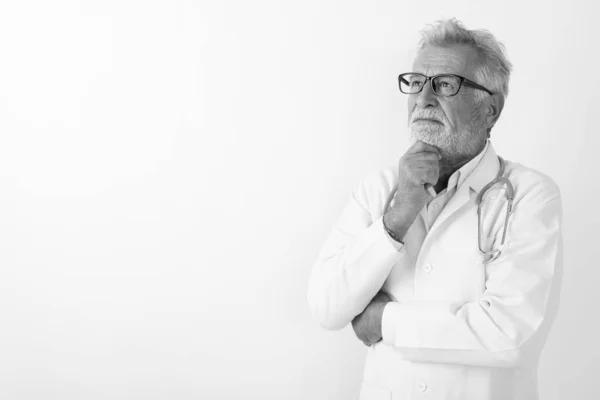 Studio colpo di bello anziano barbuto uomo medico pensare contro sfondo bianco — Foto Stock