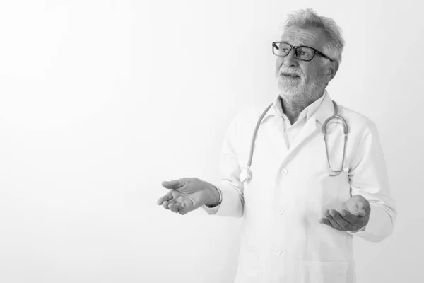 Studio colpo di bello anziano barbuto uomo medico pensando, mentre guardando confuso contro sfondo bianco — Foto Stock