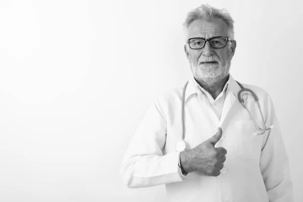 Studio colpo di bello anziano barbuto uomo medico dando pollice su contro sfondo bianco — Foto Stock