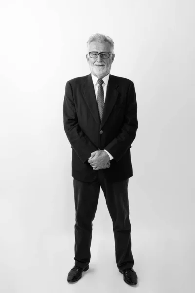 Helkroppsbild av glad senior skäggig affärsman ler och står när du bär glasögon mot vit bakgrund — Stockfoto