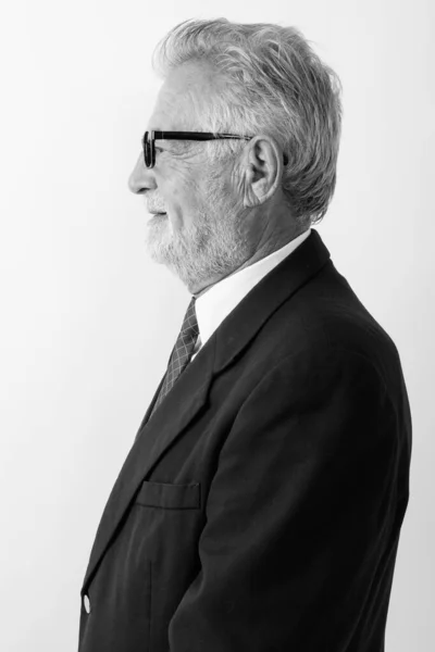 Vue du profil de l'homme d'affaires barbu heureux souriant tout en portant des lunettes sur fond blanc — Photo