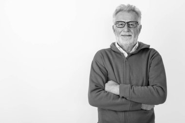 Beyaz arka planda kolları kavuşturulmuş, gülümseyen mutlu yaşlı sakallı adamın stüdyo fotoğrafı.
